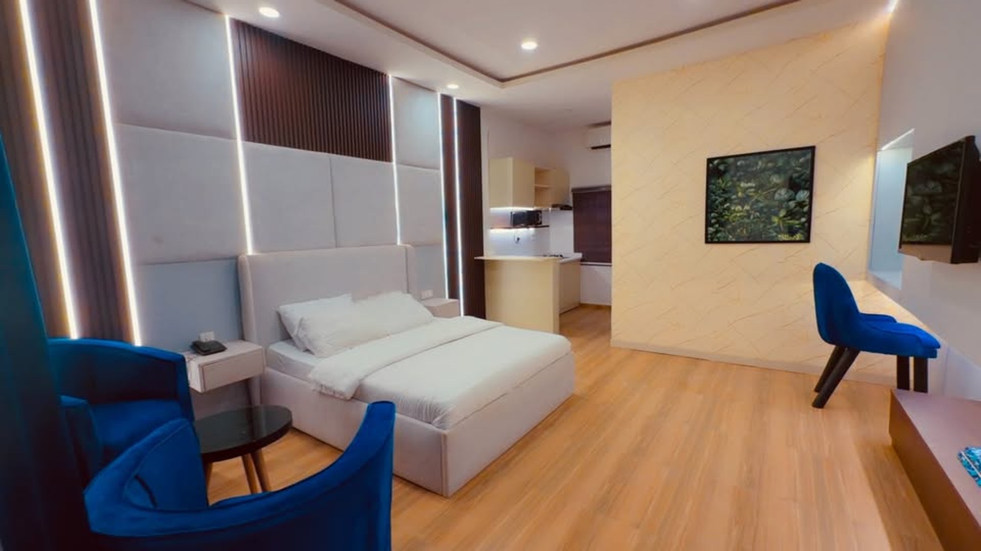 Studio Deluxe living room with cream sofa, blue velvet chairs and LED cove ceiling