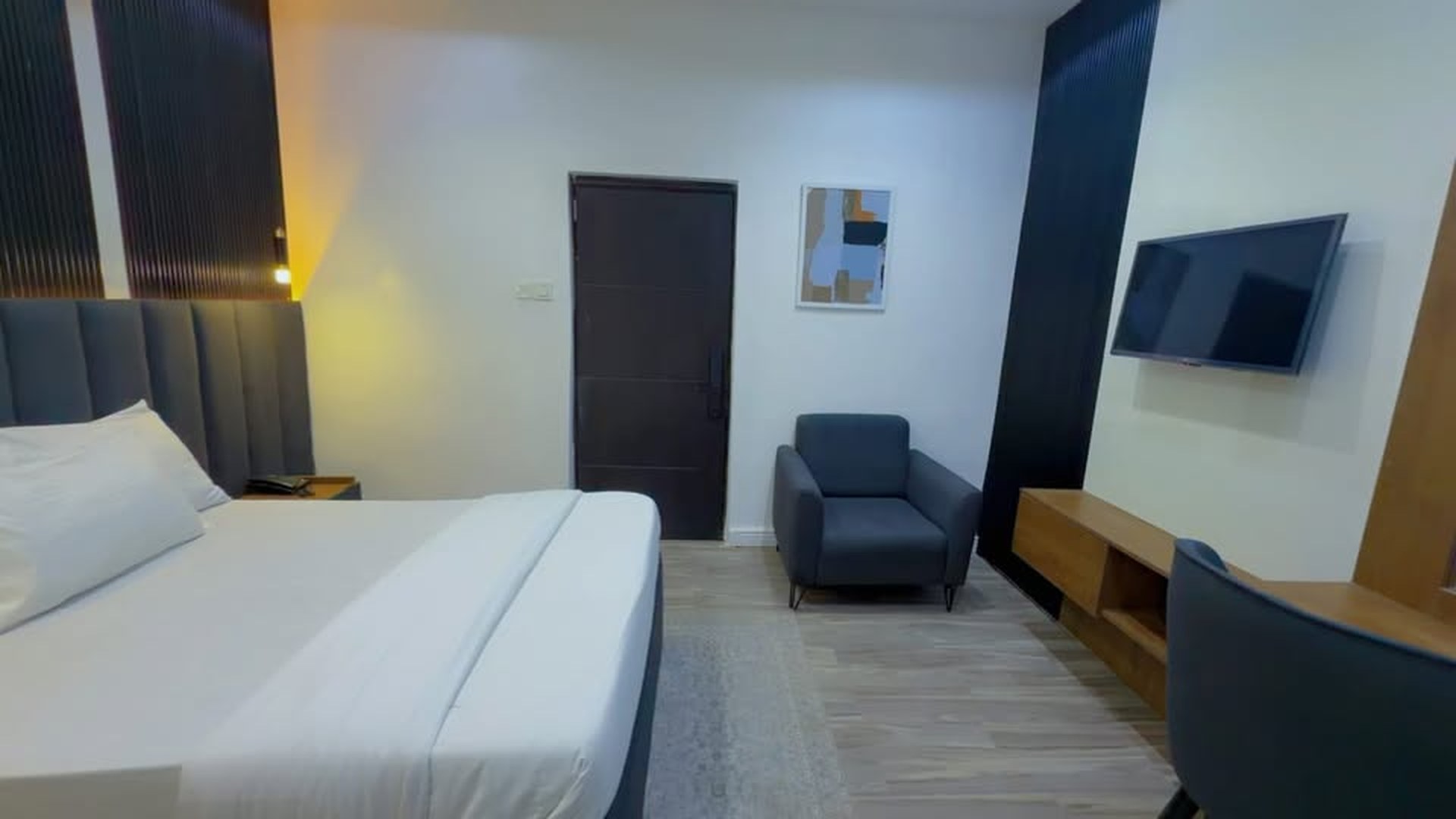 Standard 2 room with grey sofa, smart TV and framed art