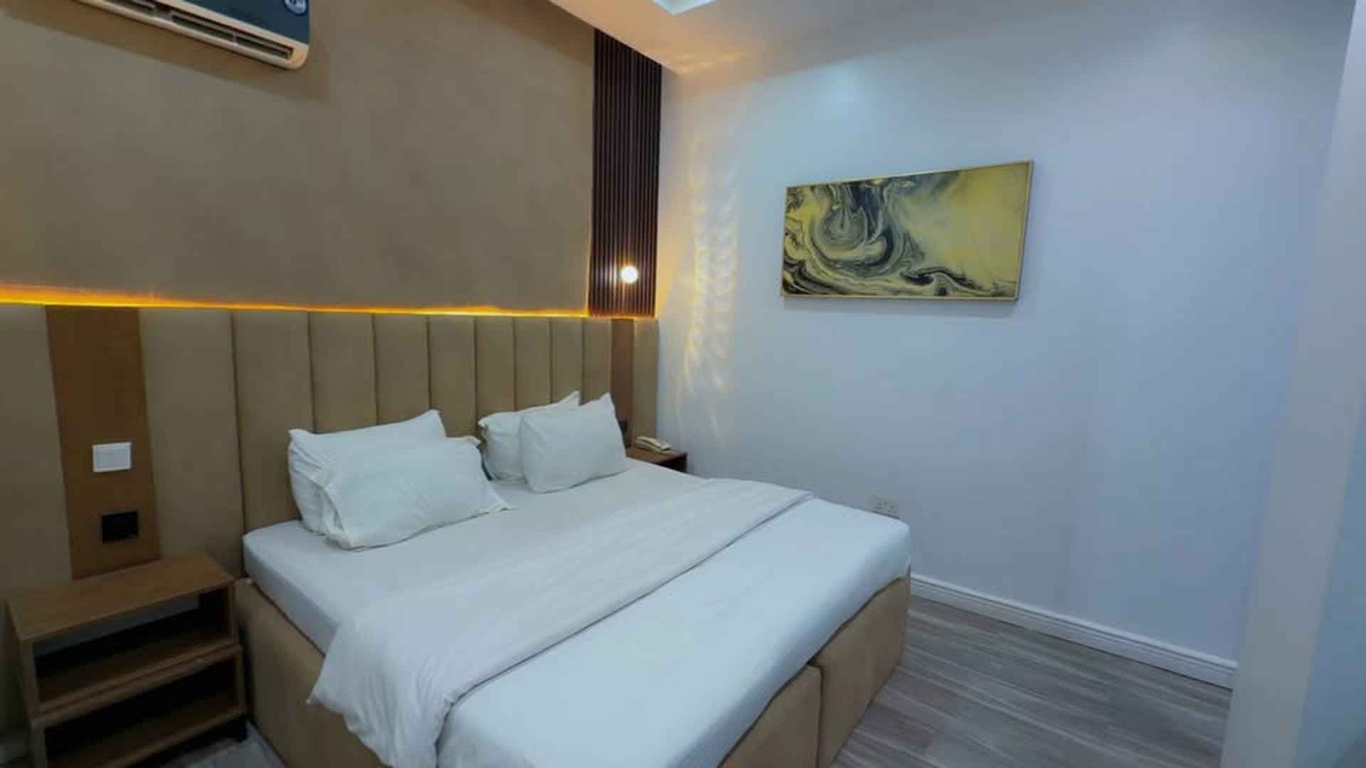 Super Deluxe Mini king bed with padded headboard and cove lighting