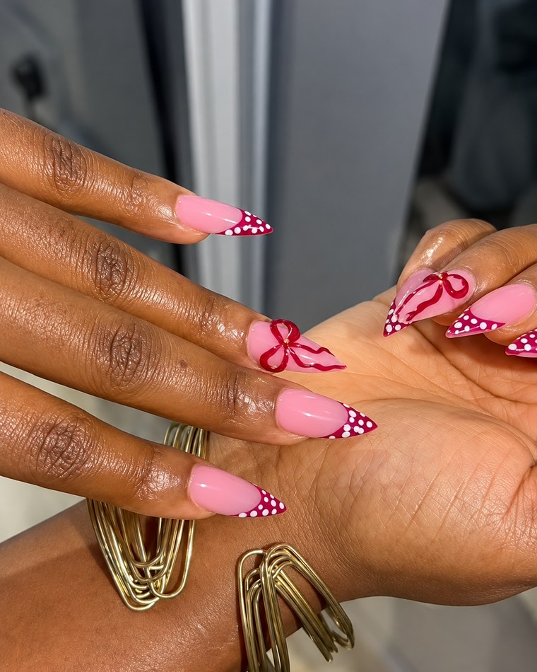 Pink almond nails with red bow and polka dot tips